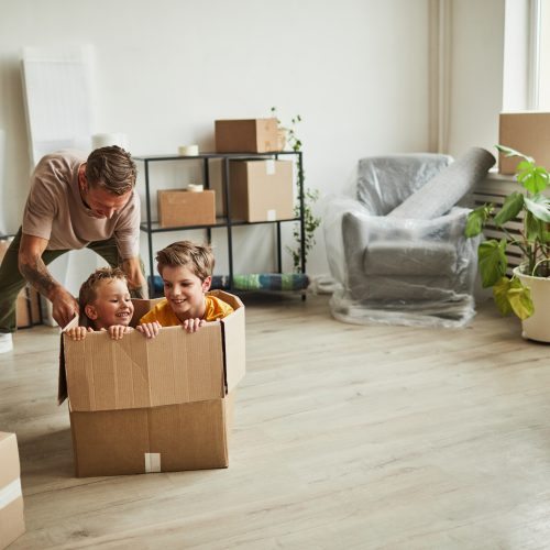 Father Playing with Sons in New Home