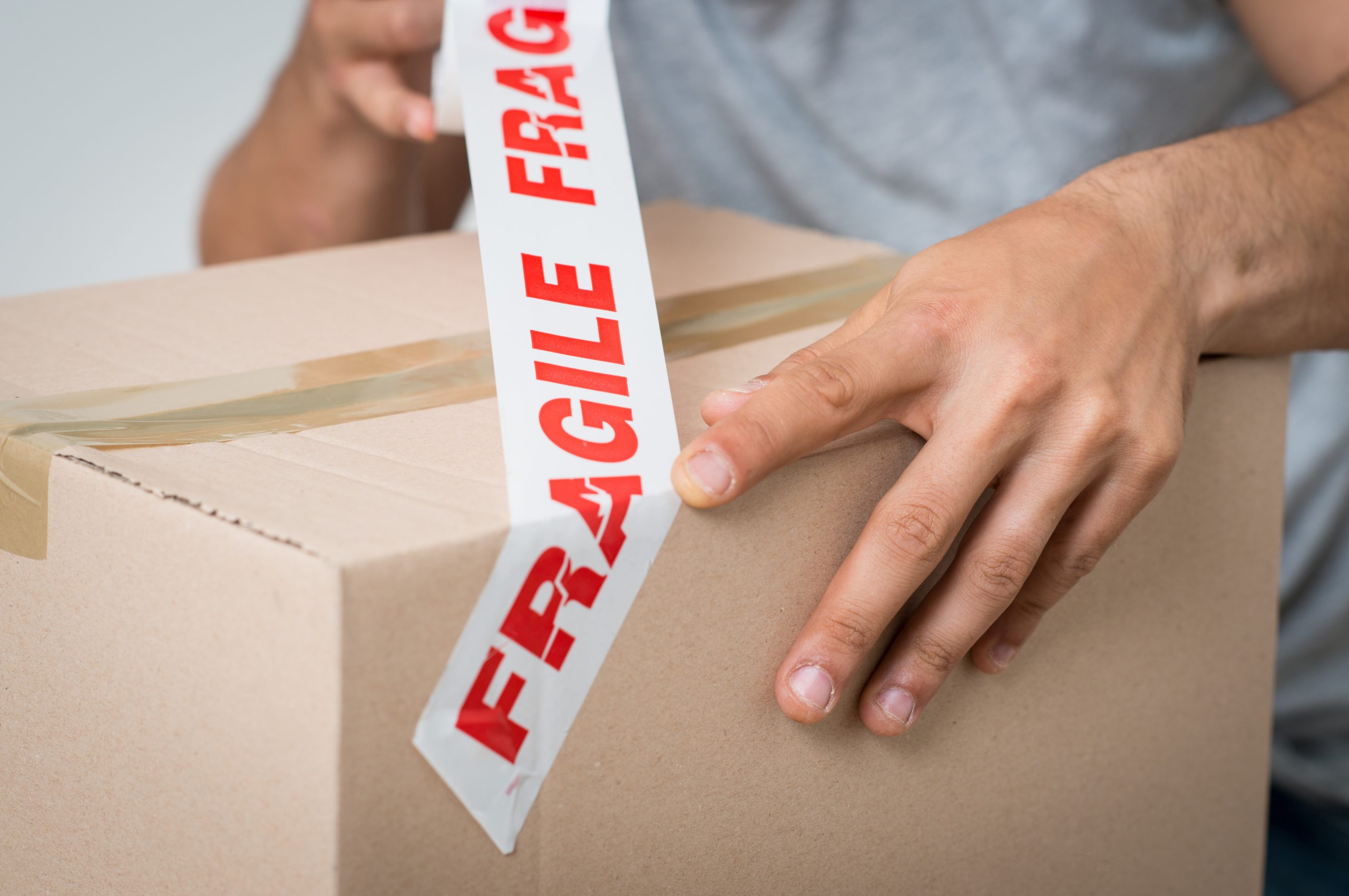 Man Sealing Box With Fragile Adhesive